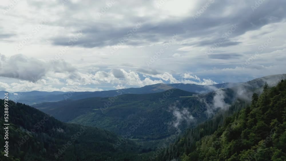 Aerial drone view of the mountain, the valley, the forest and the low clouds below the Vosges Schlucht pass, by gray cloudy weather Aerial drone view of the mountain, the valley, the forest and the low clouds below the Vosges Schlucht pass, by gray cloudy weather