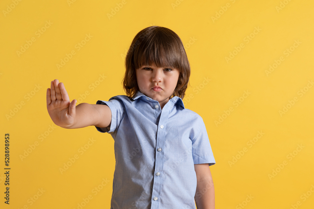 No, bad idea. Studio portrait of cute displeased little boy frowning face and gesturing stop to camera No, bad idea. Studio portrait of cute displeased little boy frowning face and gesturing stop to camera