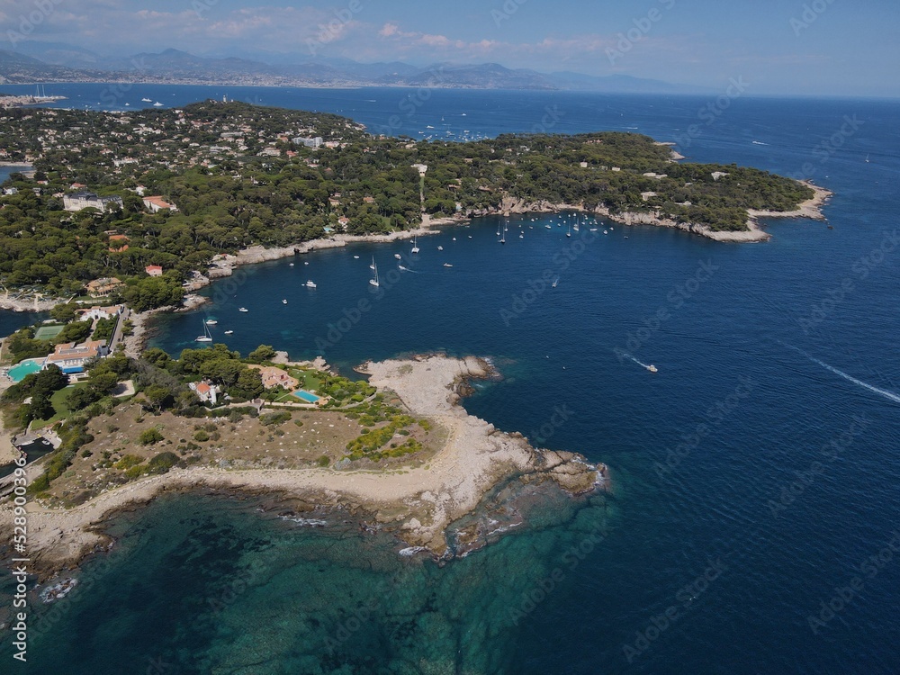 Aerial view of Cap d'Antibes and  Billionaire's Bay. Beautiful rocky beach near coastal path on the Cap d'Antibes, Antibes, France. Drone view from above of Côte d’Azur near Juan-les-Pins and Cannes.