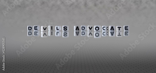 devils advocate word or concept represented by black and white letter cubes on a grey horizon background stretching to infinity