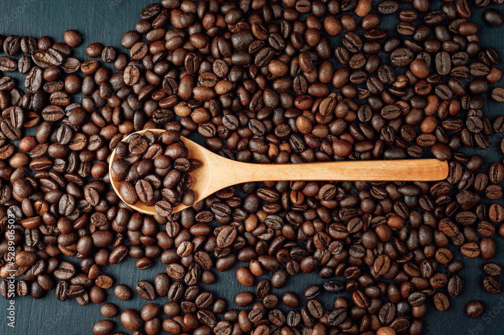 spoon with coffee on a black background. spoon with coffee beans. coffee bean. Texture of roasted coffee beans . spoon with coffee on a black background. spoon with coffee beans. coffee bean. Texture of roasted coffee beans .