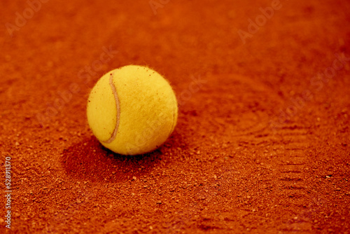 the ball for tennis lies on the red court, sports