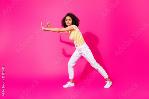 Full size photo of young attractive nice girl push hard difficult abstract empty space object serious isolated on pink color background © deagreez