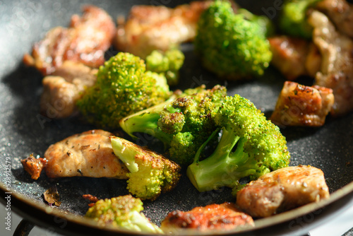 Obraz na płótnie Fried meat and broccoli in a pan close-up.