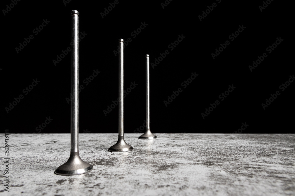 Car engine valves on the table and black background. Part of an internal combustion engine. Car engine valves on the table and black background. Part of an internal combustion engine.