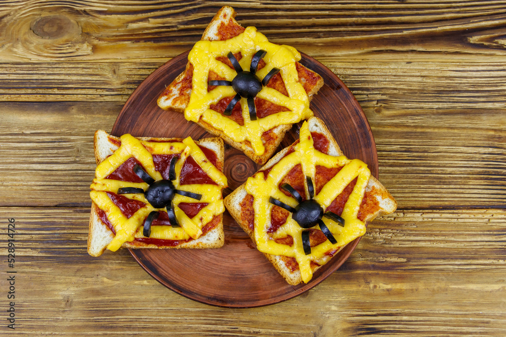 Funny sandwiches with spider and spider web for Halloween party on wooden table. Top view Funny sandwiches with spider and spider web for Halloween party on wooden table. Top view