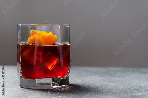 Traditional recipe.Classic cocktail Negroni with gin, campari, red vermouth, oragne on a background