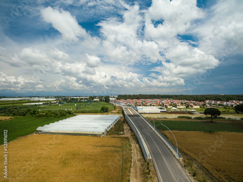 Aerial take of photo vegetable greenhouse by the roadside near the town