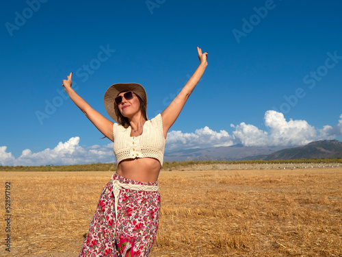 Woman gesturing V sign in field © Juan