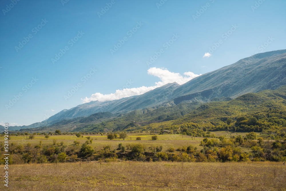 Fototapeta premium plowed field against the background of mountains in Albania. Agricultural landscape