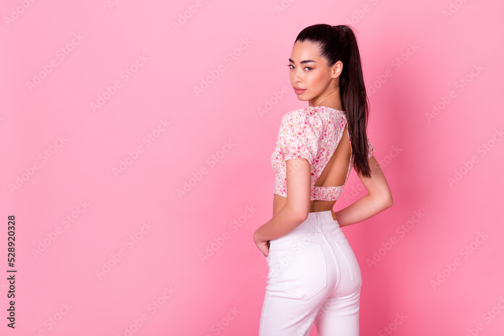 Rear behind photo of adorable indonesian lady posing empty space isolated on pink color background Rear behind photo of adorable indonesian lady posing empty space isolated on pink color background