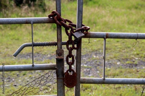 Old Rusting Chain and Padlocks on a Metal Farm Field Gate