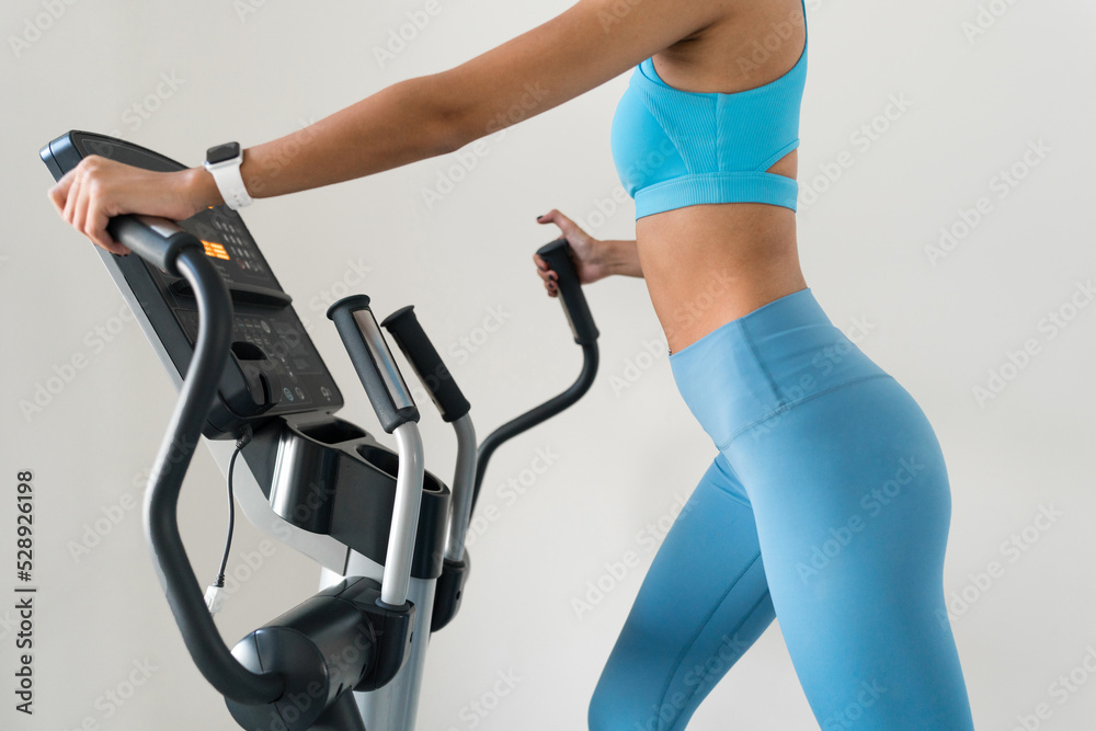 Young woman training at the gym using eliptical crosstrainer Young woman training at the gym using eliptical crosstrainer