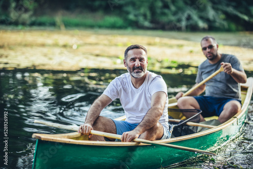 Two adults rowing Kayak On Lake Together.