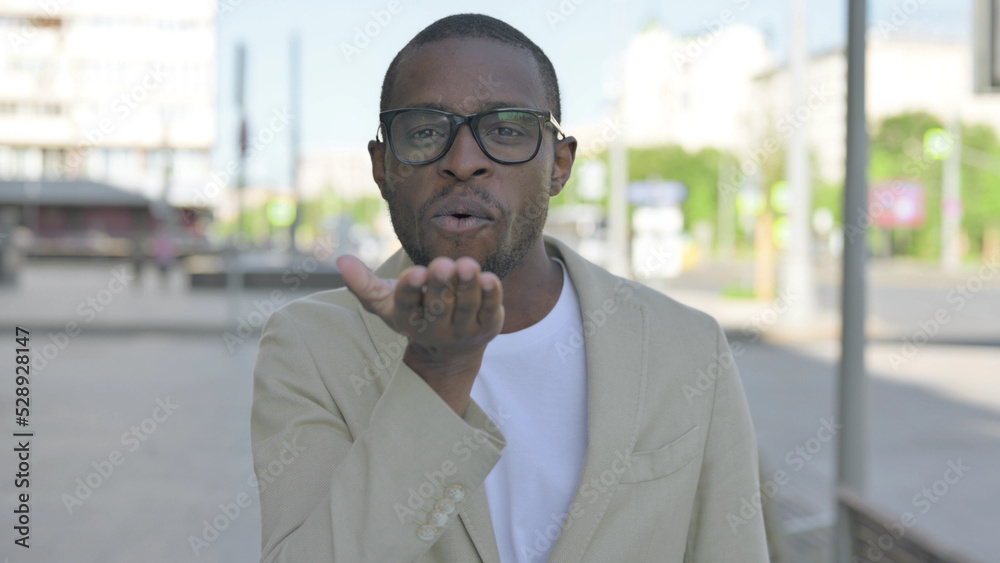 Naklejka premium Loving African Man Giving Flying Kiss by Hands Outdoor