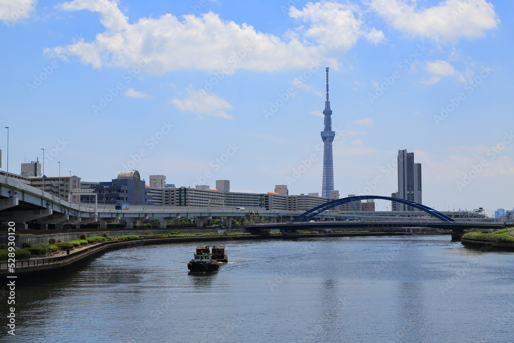 隅田川を遡上するタグボートとランドマークタワー