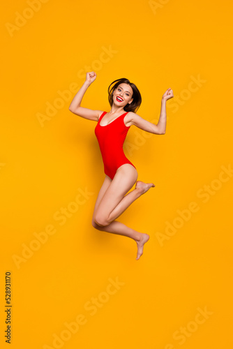 Fototapeta Naklejka Na Ścianę i Meble -  Full size vertical portrait of delighted overjoyed gorgeous person jump raise fists celebrate isolated on yellow color background