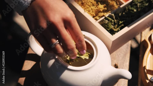 close up video of woman making some herbal tea in pot.