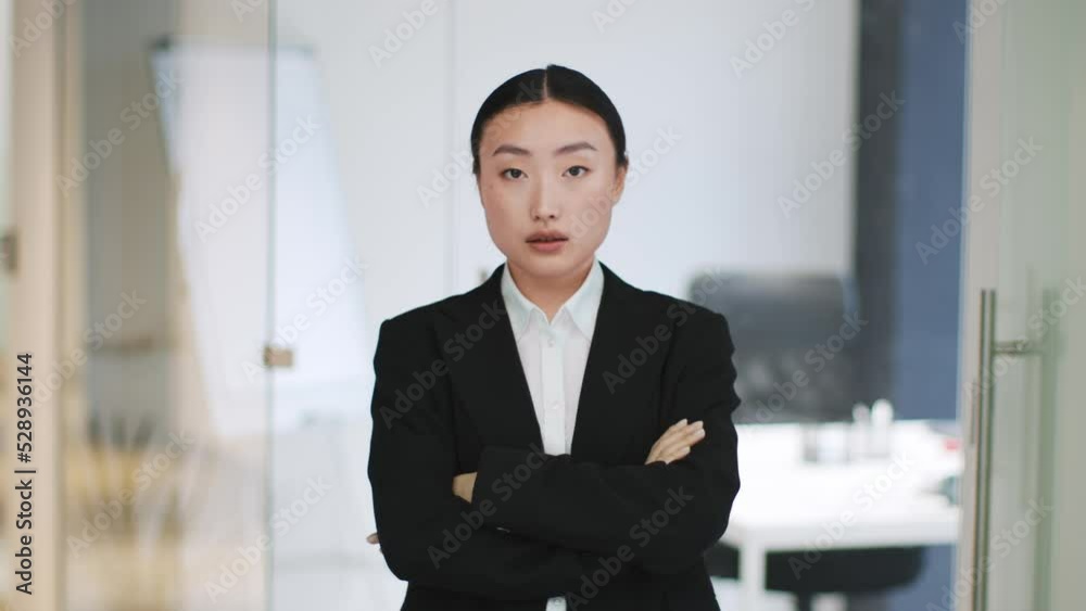 Confident professional asian woman manager crossing hands and looking seriously to camera, possing at office interior Confident professional asian woman manager crossing hands and looking seriously to camera, possing at office interior