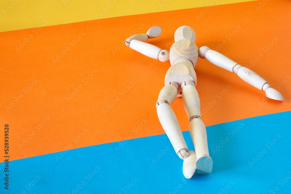 Concept of a tourist resting on the shore of the beach enjoying his vacation with an articulated wooden doll Concept of a tourist resting on the shore of the beach enjoying his vacation with an articulated wooden doll