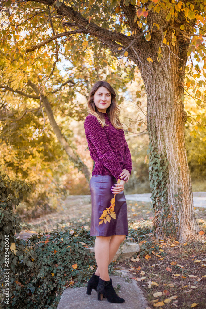 Beautiful woman in burgundy sweater on a background of autumn tree. Beautiful woman in burgundy sweater on a background of autumn tree.