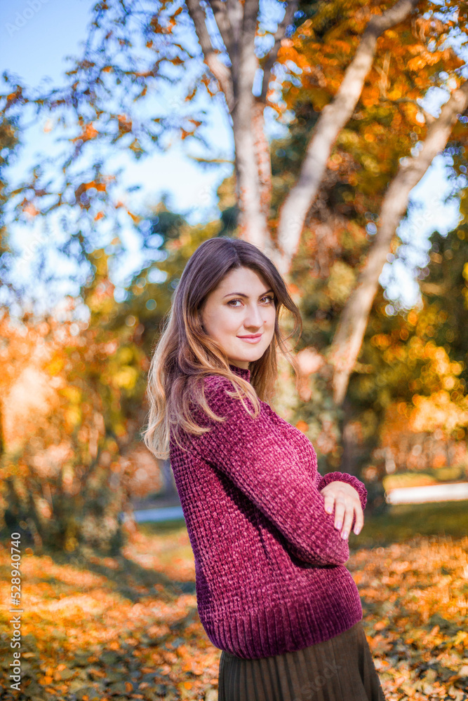 Portrait of beautiful woman in burgundy sweater on a background of autumn tree.
Portrait of beautiful woman in burgundy sweater on a background of autumn tree.