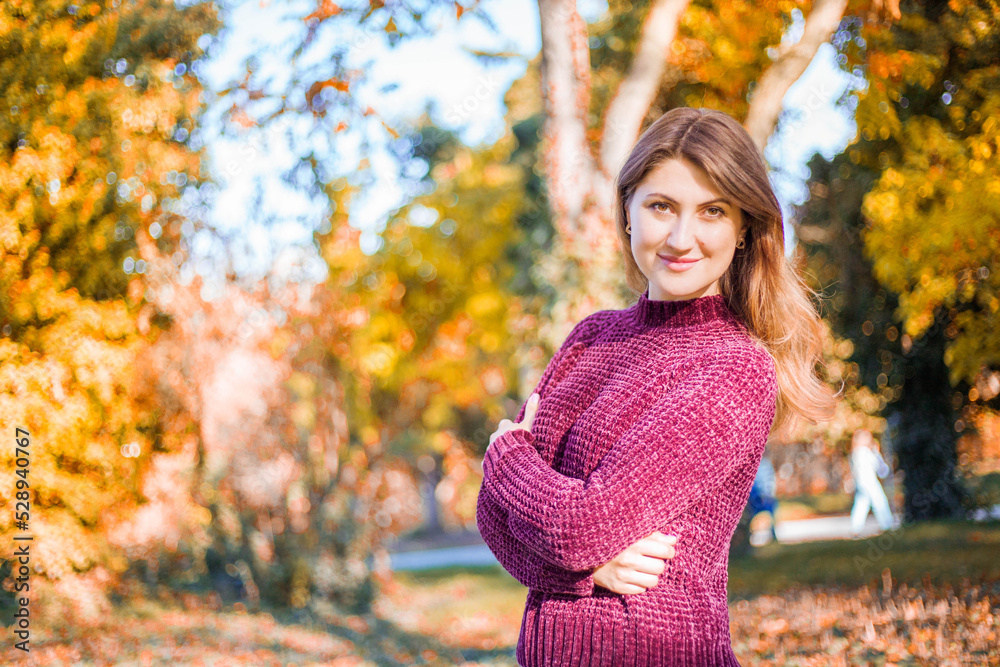 Portrait of beautiful woman in burgundy sweater on a background of autumn tree.
Portrait of beautiful woman in burgundy sweater on a background of autumn tree.