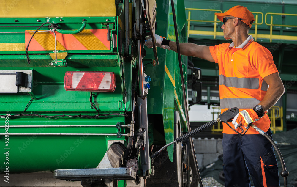 Garbage Truck Worker with Pressure Washer Lance in His Hands Garbage Truck Worker with Pressure Washer Lance in His Hands