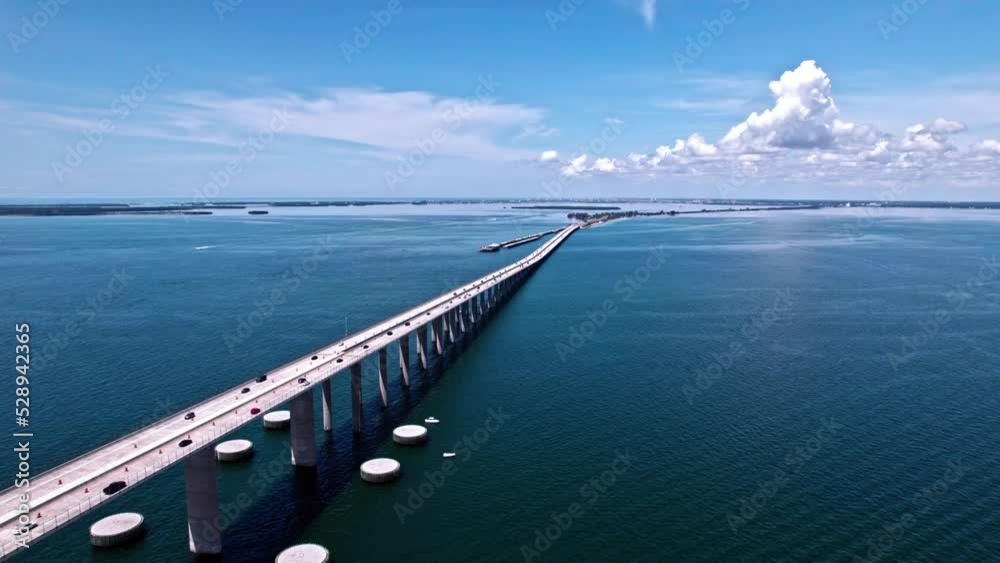 Traffic On The Sunshine Skyway Bridge Spanning Lower Tampa Bay In Florida. Concrete Dolphins Built Out From The Bridge Pylons. aerial drone Traffic On The Sunshine Skyway Bridge Spanning Lower Tampa Bay In Florida. Concrete Dolphins Built Out From The Bridge Pylons. aerial drone