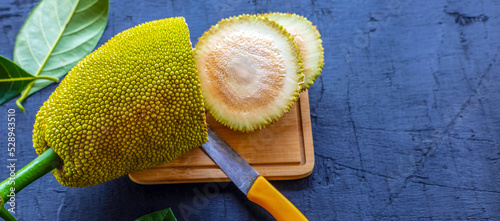 Sliced ​​fresh raw green jackfruit reveals the white pulp and white latex of the jackfruit.