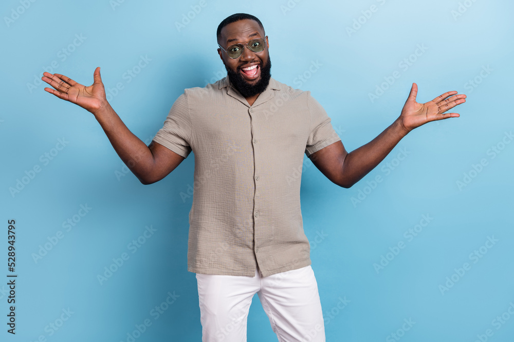 Photo of positive glad young person raise opened arms have good mood isolated on blue color background Photo of positive glad young person raise opened arms have good mood isolated on blue color background