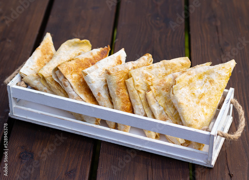 Lavash pies on a white wooden tray.
