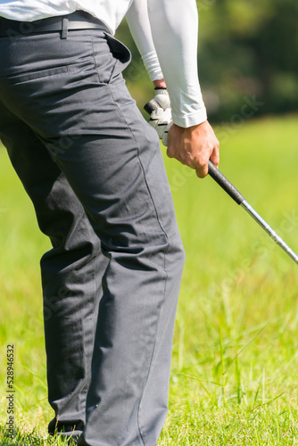 Close up professional golf player with club on course