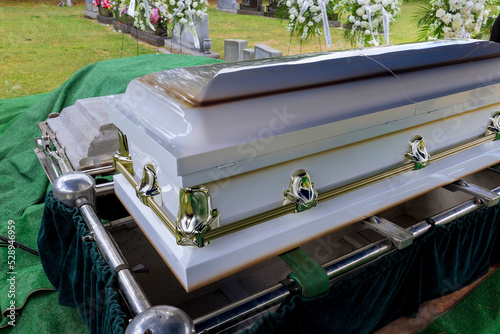 Obraz na plátně As part of the funeral service in a cemetery, coffin is placed on an automatic e