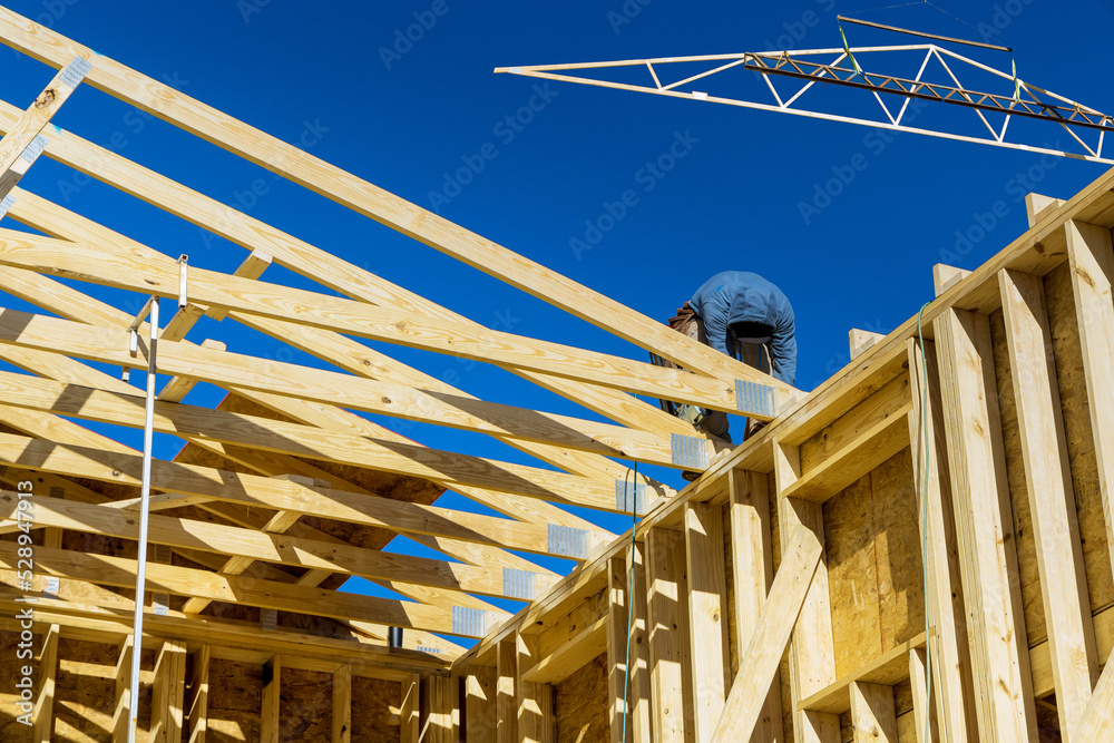 As part of a household construction project, worker uses an air nail ...