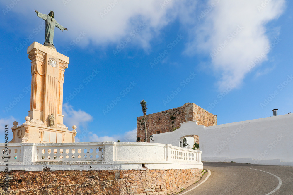 Estatua de Cristo a la entrada del santuario de la Virgen del Toro, en la cima de Monte Toro, la montaña más alta de la isla de Menorca. - obrazy, fototapety, plakaty 