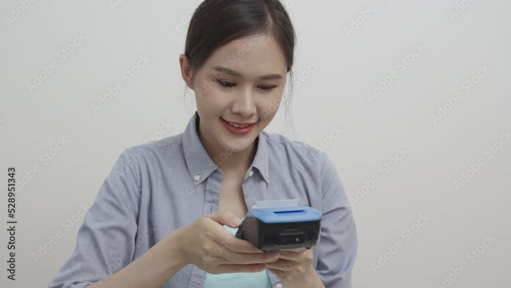 Beautiful woman uses a wireless POS machine to print receipts. Beautiful woman uses a wireless POS machine to print receipts.