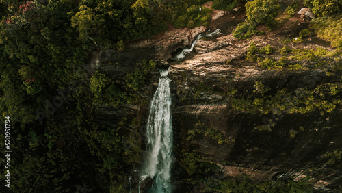 Obraz na płótnie Natural Landscape with a huge waterfall from the mountains, green hills and jungle, Diyaluma in Sri Lanka. w salonie