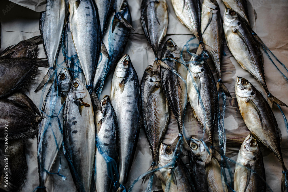 Obraz premium Sun-dried fish on paper for sale in the Ban Na Kluea market, Pattaya, Thailand.