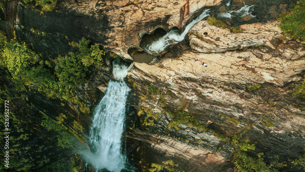 Natural Landscape with a huge waterfall from the mountains, green hills and jungle, Diyaluma in Sri Lanka.