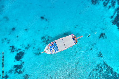 Drone photo top view of boat in turquoise sea bay