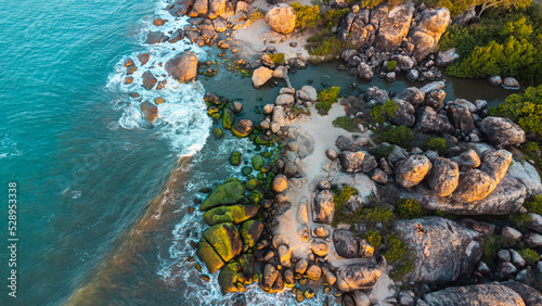 Ocean tropical landscape, rocky coast with fishing boats, drone shot, water and beach.
