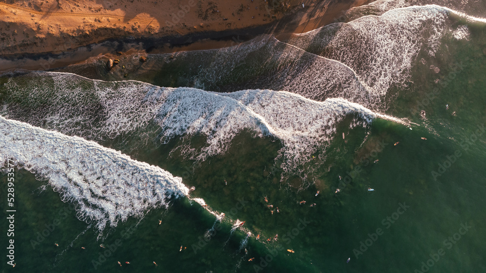 Beautiful view of the sea and the ocean with surfers waiting for the waves.