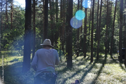 a man in the forest, hiking, on the grass around blueberries, a cocked hat and a blue vest