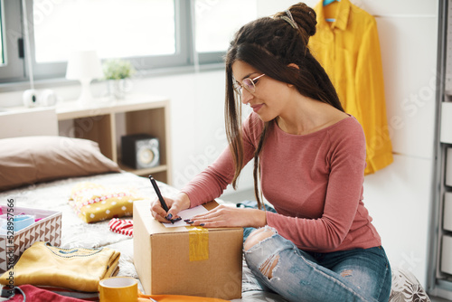 Woman preparing a box with her used clothes
