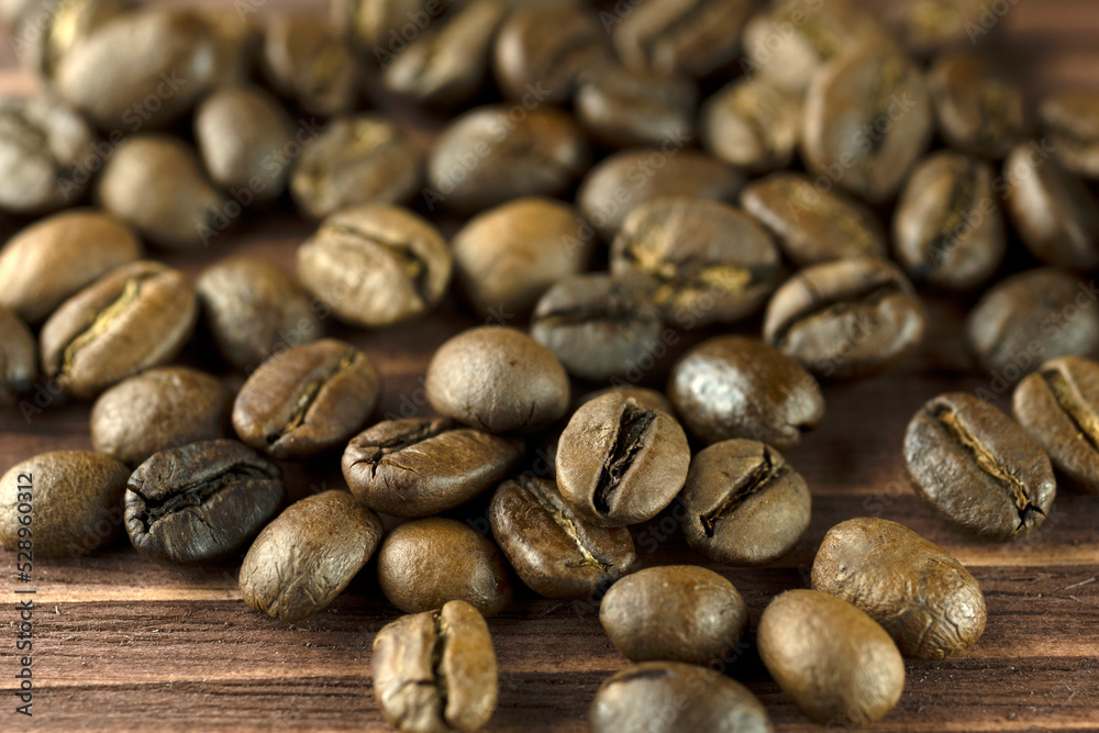 Roasted coffee beans on a wooden brown background, close-up. Roasted coffee beans on a wooden brown background, close-up.