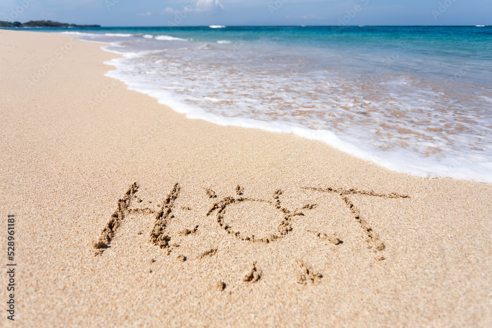 Fototapeta premium The word HOT written in the sand on beach