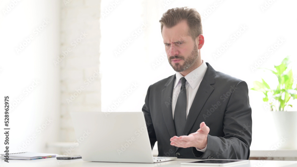Young Businessman Reacting to Loss While using Laptop Young Businessman Reacting to Loss While using Laptop