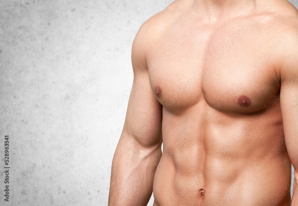 Handsome muscular young man posing against a background. Handsome muscular young man posing against a background.