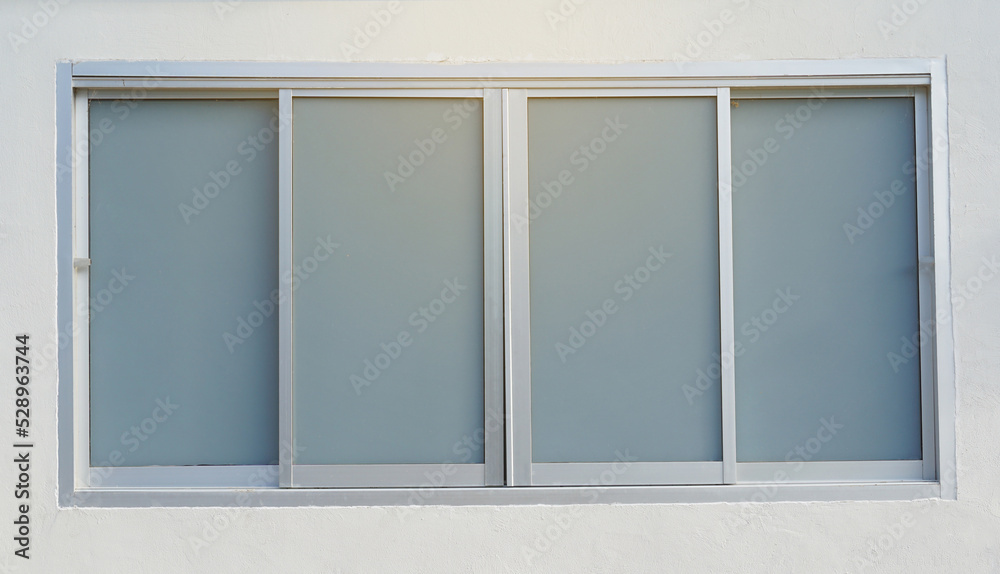 Aluminum sliding window, 4 panels, glass attached with gray glass film sticker. Soft and selective focus. Aluminum sliding window, 4 panels, glass attached with gray glass film sticker. Soft and selective focus.